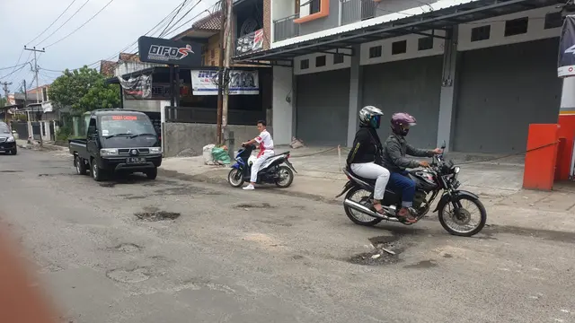 Sejumlah pengendara di Jalan KH Hasan Arif, Garut, Jawa Barat, terpaksa menepi akibat banyaknya jalan rusak di sepanjang jalan itu yang kerap menyebabkan kecelakaan.