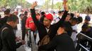 Aksi The Jakmnia mengangkat tangan saat jalani pemeriksaan sebelum menonton laga Piala AFC 2018 antara Persija jakarta vs Song Lam Nghe An di Stadion Utama GBK, Rabu (14/3/2018). Panpel menjual sekitar 65.000 lembar tiket. (Bola.com/Surya Bima Mahendarta)