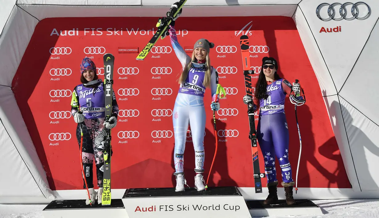 Lindsey Vonn dari Amerika Serikat (tengah) merayakan kemenangannya pada kompetisi FIS Alpine World Cup Women's Downhill di Cortina d'Ampezzo, Pegunungan Alpen Italia (20/1). (AFP Photo/Tiziana Fabi)