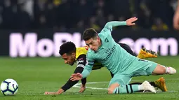 Gelandang Arsenal, Lucas Torreira berebut bola dengan gelandang Watford, Etienne Capoue dalam laga lanjutan Premier League 2018-19 pekan ke-34 di Vicarage Road, Senin (15/4). Arsenal sukses mengalahkan tuan rumah Watford dengan skor tipis 1-0. (Ben STANSALL / AFP)