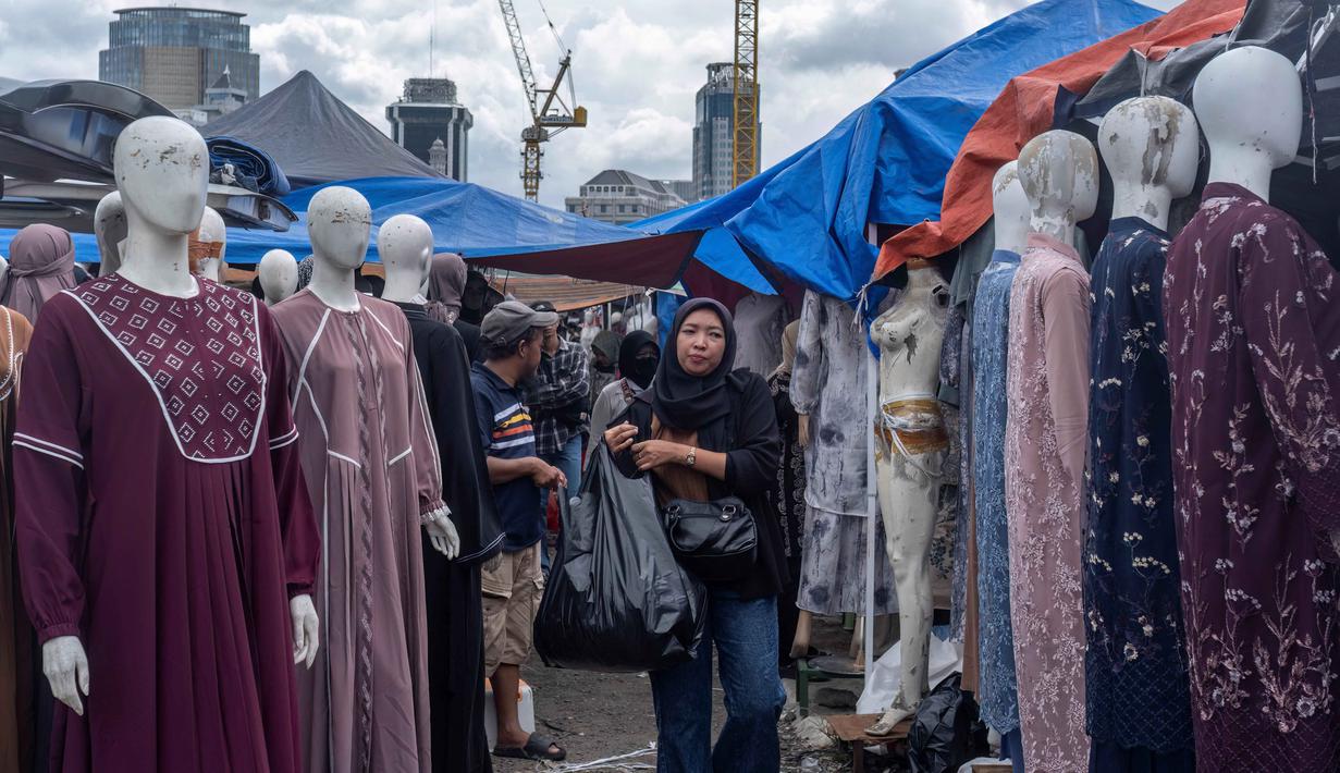 Pemerintah juga akan memberantas praktik thrifting illegal. Tampak dalam foto, pembeli berjalan di antara kios-kios penjual pakaian lokal di salah satu pasar tradisional, Jakarta, Kamis 20 November 2025. (BAY ISMOYO/AFP)
