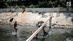 Sejumlah anak-anak bermain di kali menteng, Jakarta, Selasa (20/8/2019). Kurangnya lahan bermain membuat mereka terpaksa memanfaatkan kali menteng yang kotor sebagai tempat bermain. (Liputan6.com/Faizal Fanani)