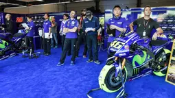 Staf mekanik  berdiri dekat motor Valentino Rossi saat sang pebalap melakukan tese bebas pada balapan San Marino Moto GP Grand Prix di Marco Simoncelli Circuit, Misano (9/9/2017). (AFP/Andreas Solaro)