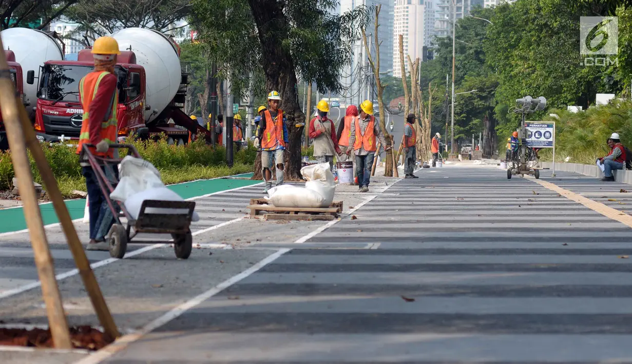 Sejumlah pekerja melakukan pengerjaan tahap akhir renovasi trotoar di sekitar Jalan Gerbang Pemuda, Senayan, Jakarta, Selasa (29/5). Renovasi sebagai bagian persiapan pelaksanaan Asian Games 2018. (Liputan6.com/Helmi Fithriansyah)