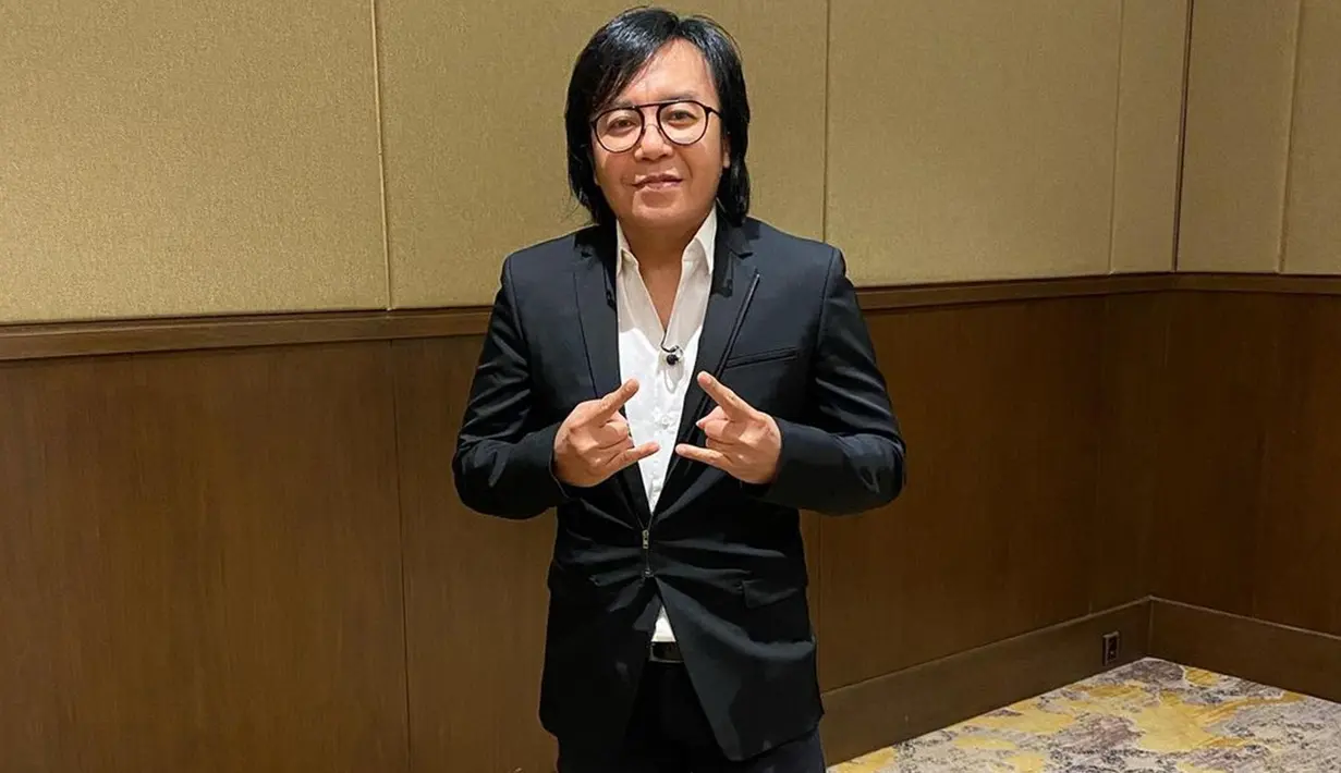 Ini dia penampilan Ari Lasso saat memakai setelan jas berwarna hitam dengan kemeja putih. Gaya rockernya pun tak pernah lepas darinya meski tengah menggunakan setelan formal. (Liputan6.com/IG/@ari_lasso)