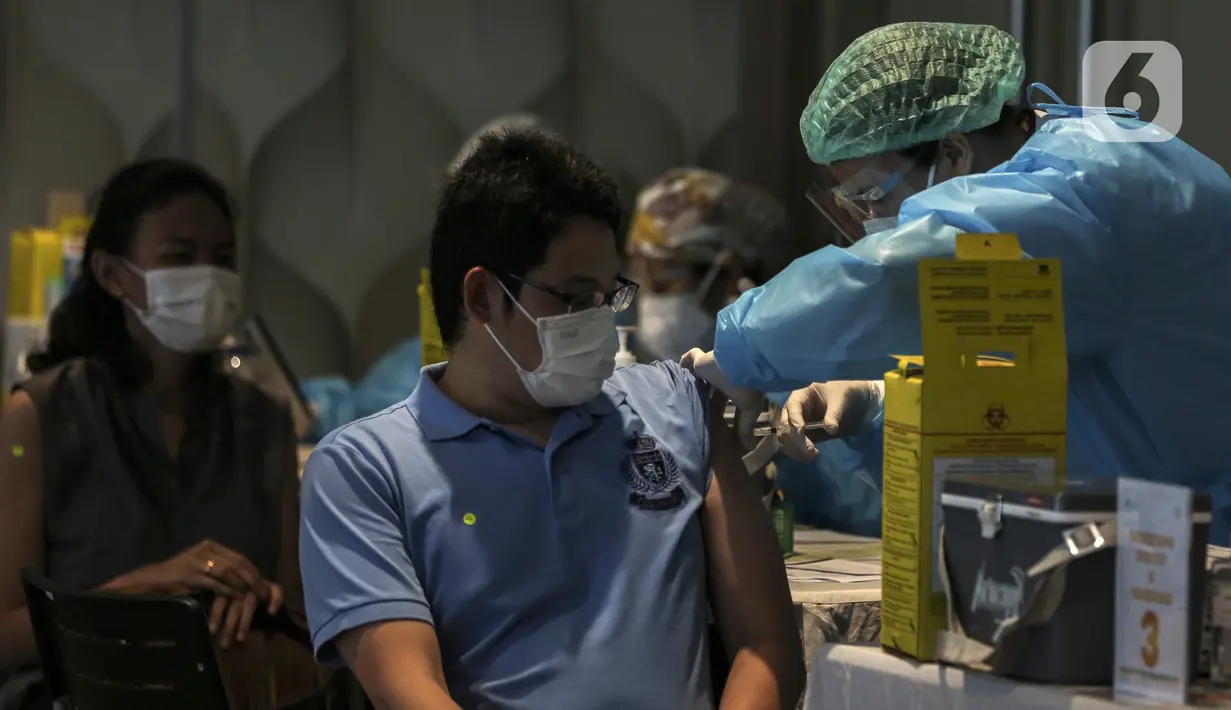 Vaksinator menyuntikkan vaksin AstraZeneca kepada warga saat peresmian Sentra Vaksinasi COVID-19 di RS St. Carolus, Jakarta, Senin (14/6/2021). Sentra vaksinasi ini melayani warga 18 tahun ke atas, pralansia, serta pekerja pariwisata dan ekonomi kreatif. (Liputan6.com/Johan Tallo)