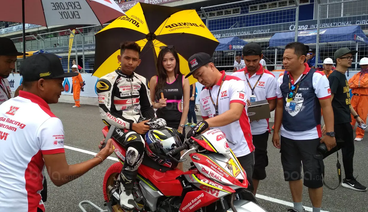 Para Umbrella Girl memayungi pebalap saat Asia Road Racing Championship (ARRC) 2017 di Sirkuit Buriram, Thailand, Sabtu (2/12/2017). Kehadiran para umbrella girl menjadi daya tarik tersendiri di lintasan balap. (Bola.com/Muhammad Wirawan)