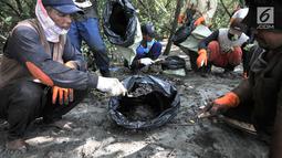 Nelayan mengumpulkan tumpahan limbah minyak (oil spill) yang mencemari Pantai Muara Beting, Muara Gembong, Bekasi, Jawa Barat, Minggu (28/7/2019). Pertamina mengajak nelayan setempat untuk mengumpulkan oil spill yang nantinya akan dipindahkan ke penyimpanan limbah B3. (merdeka.com/Iqbal Nugroho)