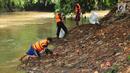 Sejumlah petugas PPSU atau pasukan oranye memunguti rumput liar dan sampah mengendap di tepi kali Ciliwung, Lenteng Agung , Jakarta, Sabtu (28/10). Hal tersebut dilakukan demi menjaga kebersihan kali Ciliwung. (Liputan6.com/Helmi Afandi)