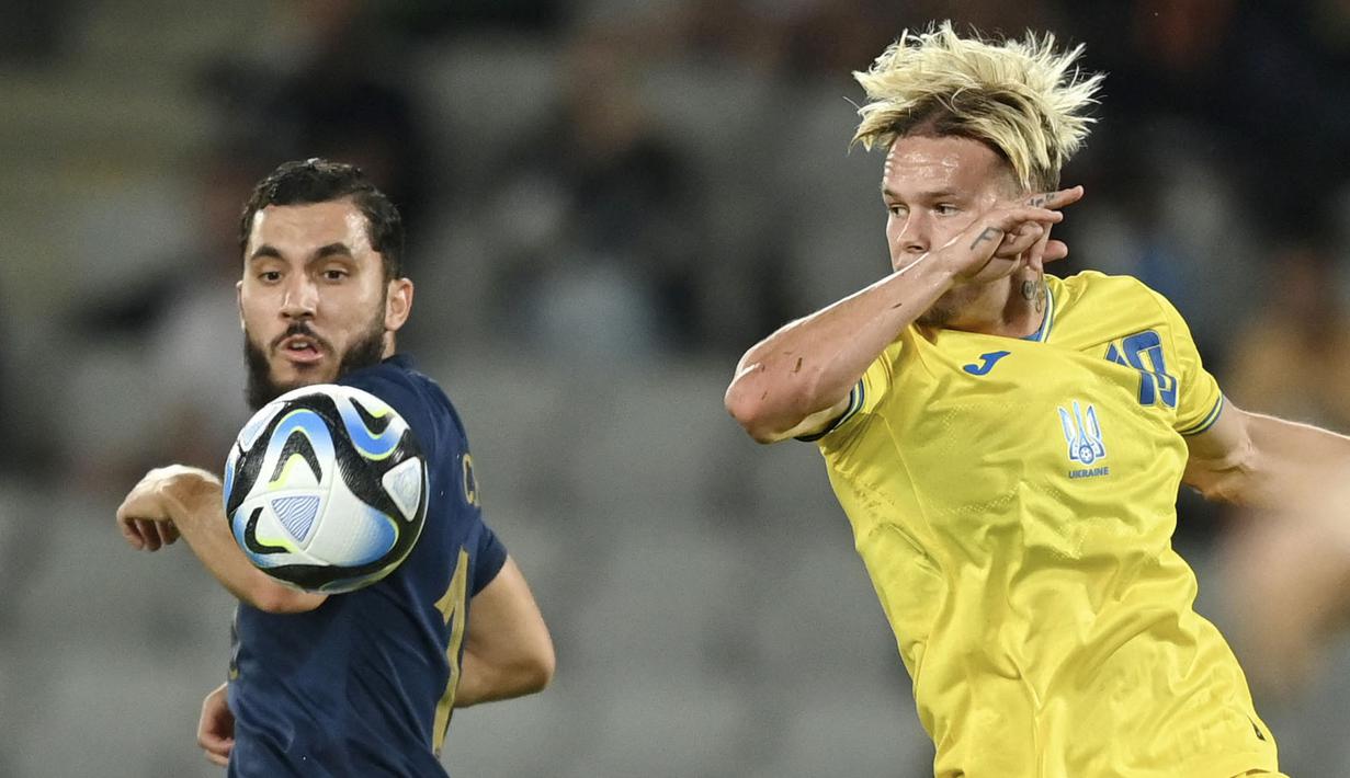 Pemain Timnas Prancis U-21, Rayan Cherki, berebut bola dengan pemain Ukraina, Mykhailo Mudryk, pada laga perempat final Euro U-21 2023 di Cluj Arena, Rumania, Senin (3/7/2023). Ukraina menang dengan skor 3-1. (Photo by MIHAI BARBU / AFP)