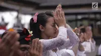 Seorang Umat Hindu berdoa dalam prosesi ritual tahunan Purnama Kapat di tengah aktivitas Gunung Agung pada level awas di Pura Besakih, Karangasem, Bali, Kamis (5/10). Ritual setahun sekali ini digelar setiap bulan purnama. (Liputan6.com/Gempur M Surya)