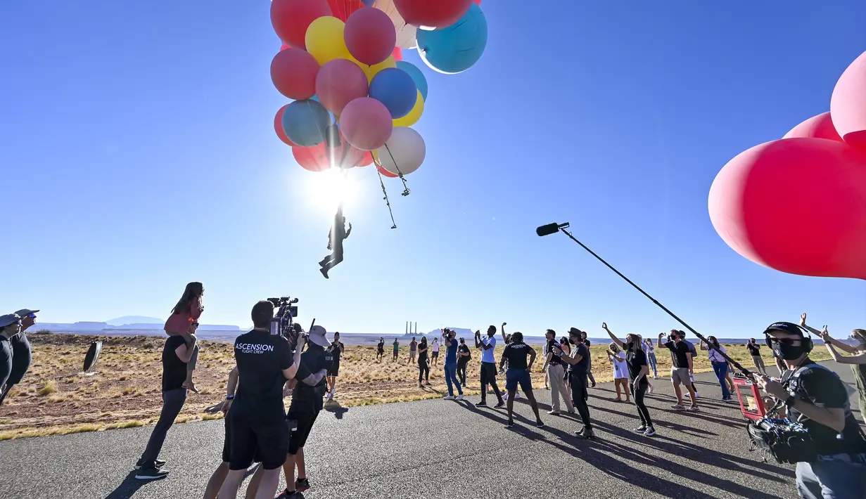 David Blaine terbang dengan memegang balon helium saat melakukan aksi "Ascension" di Page, Arizona, Amerika Serikat, Rabu (2/9/2020). Aksi tersebut mencetak rekor baru sebagai acara langsung YouTube Originals yang paling banyak ditonton. (David Becker/GETTY IMAGES NORTH AMERICA/Getty Images via AFP)