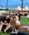 Rachel Vennya dan Okin, pasangan selebgram yang telah resmi bercerai 2 tahun lalu, baru saja mengunggah foto liburan bareng. Tak hanya berdua, Rachel Vennya dan Okin membawa kedua anaknya ke Bali. Di foto ini, Rachel tampil dengan tank top cokelat dan mini skirt putih, sedangkan Okin mengenakan kaus hitam bermotif dan celana pendek yang juga berwarna hitam. Sedangkan kedua anaknya kompak mengenakan benetton jumpsuit cokelat yang menggemaskan. Foto: Instagram.