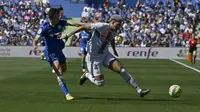 Bek Barcelona Ronald Araujo coba menghadalu pemain Getafe saat mencoba rebut bola pada pertandingan Liga Spanyol di stadion Alfonso Perez (AFP)