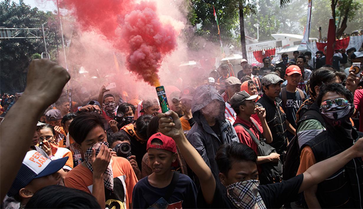 Suporter menyalakan red flare saat berunjuk rasa menuntut pencabutan SK pembekuan terhadap PSSI di Kantor Kemenpora, Jakarta, Selasa (11/8/2015). (Bola.com/Vitalis Yogi Trisna)