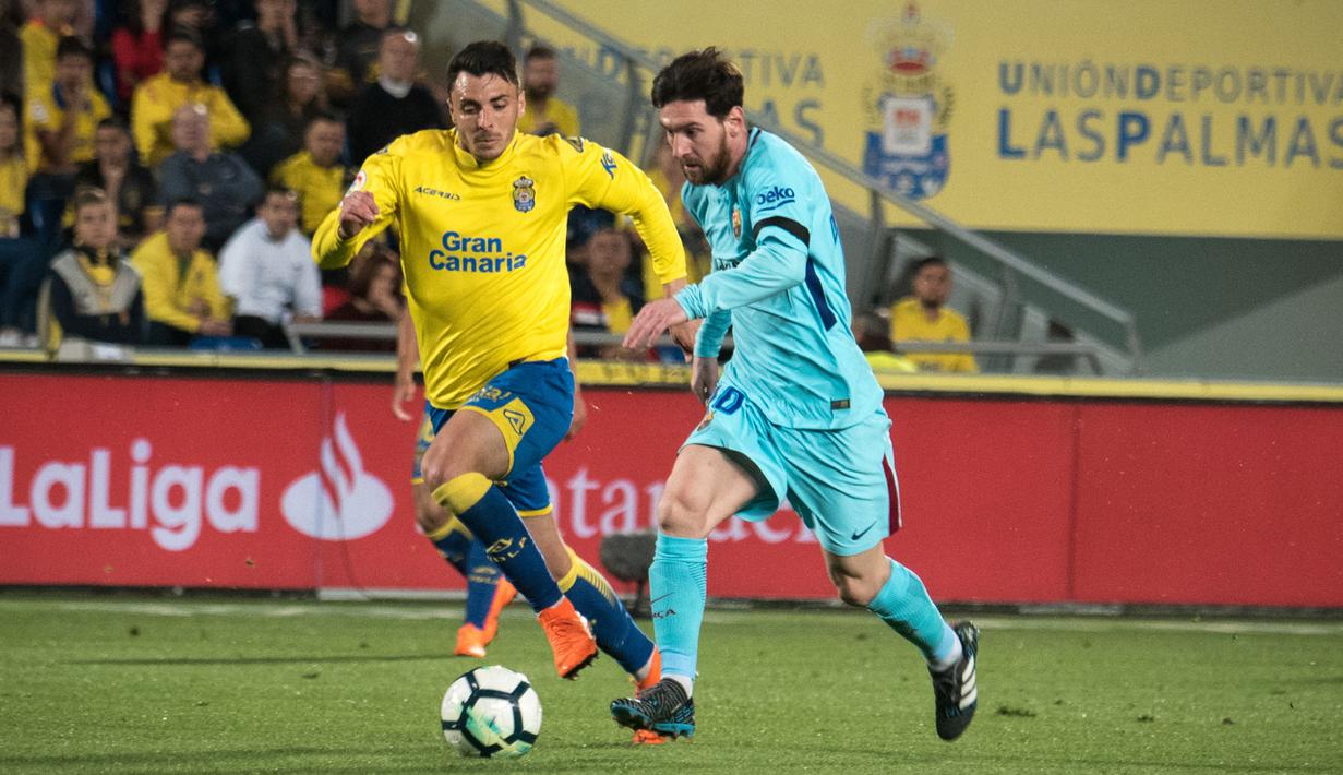 Gelandang Barcelona, Lionel Messi, menggiring bola melewati bek Las Palmas, Ximo Navarro, pada laga La Liga Spanyol di Stadion Gran Canaria, Las Palmas, Kamis (1/3/2018). Kedua klub bermain imbang 1-1. (AFP/Desiree Martin)