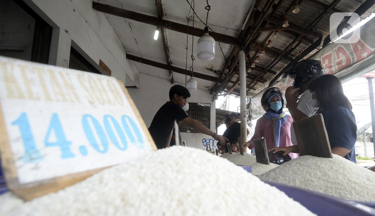 Pedagang beras melayani pembeli di pinggir Jalan Raya Pamulang, Tangerang Selatan, Banten, Jumat (11/12/2020). Jelang Natal dan Tahun Baru 2021, harga beras dipasaran masih normal tidak ada kenaikan. (merdeka.com/Dwi Narwoko)