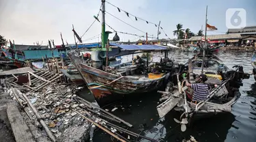 Aktivitas nelayan di dekat tumpukan sampah di Kampung Nelayan Cilincing, Jakarta Utara, Selasa (8/6/2021). Berdasarkan data  TKN PSL Kementerian Koordinator Kemaritiman dan Investasi, total sampah yang masuk ke laut Indonesia tahun 2020 diperkirakan 521.540 ton. (merdeka.com/Iqbal S. Nugroho)