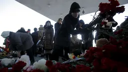 Warga meletakkan karangan bunga untuk mengenang korban jatuhnya pesawat maskapai Flydubai, di luar Bandara Rostov-on-Don, Rusia, Minggu (20/3). Insiden itu menewaskan seluruh penumpang dan kru yang berjumlah 62 orang. (REUTERS/Maxim Shemetov)