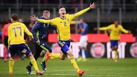 Bek Swedia, Mikael Lustig, melakukan selebrasi usai menahan imbang Italia pada laga leg kedua playoff Piala Dunia 2018, di Stadion Giuseppe Meazza, Senin (13/11/2017). Italia bermain imbang 0-0 dengan Swedia. (AFP/Marco Bertorello)