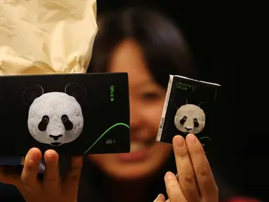 Seorang wanita menunjukkan tisu yang terbuat dari kotoran panda dan sisa makanan di Chengdu, provinsi Sichuan, China (18/12). Tisu ini dibuat oleh Qianwei Fengsheng Paper Company dan bekerjasama dengan Pusat Konservasi dan Penelitian China. (AFP Photo)