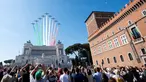 Warga menyaksikan aksi tim aerobatik Frecce Tricolori terbang mengeluarkan asap berwarna bendera Italia selama parade militer ulang tahun Hari Republik Italia ke-72 di Roma, Sabtu (2/6). (AP Photo/Claudio Peri)