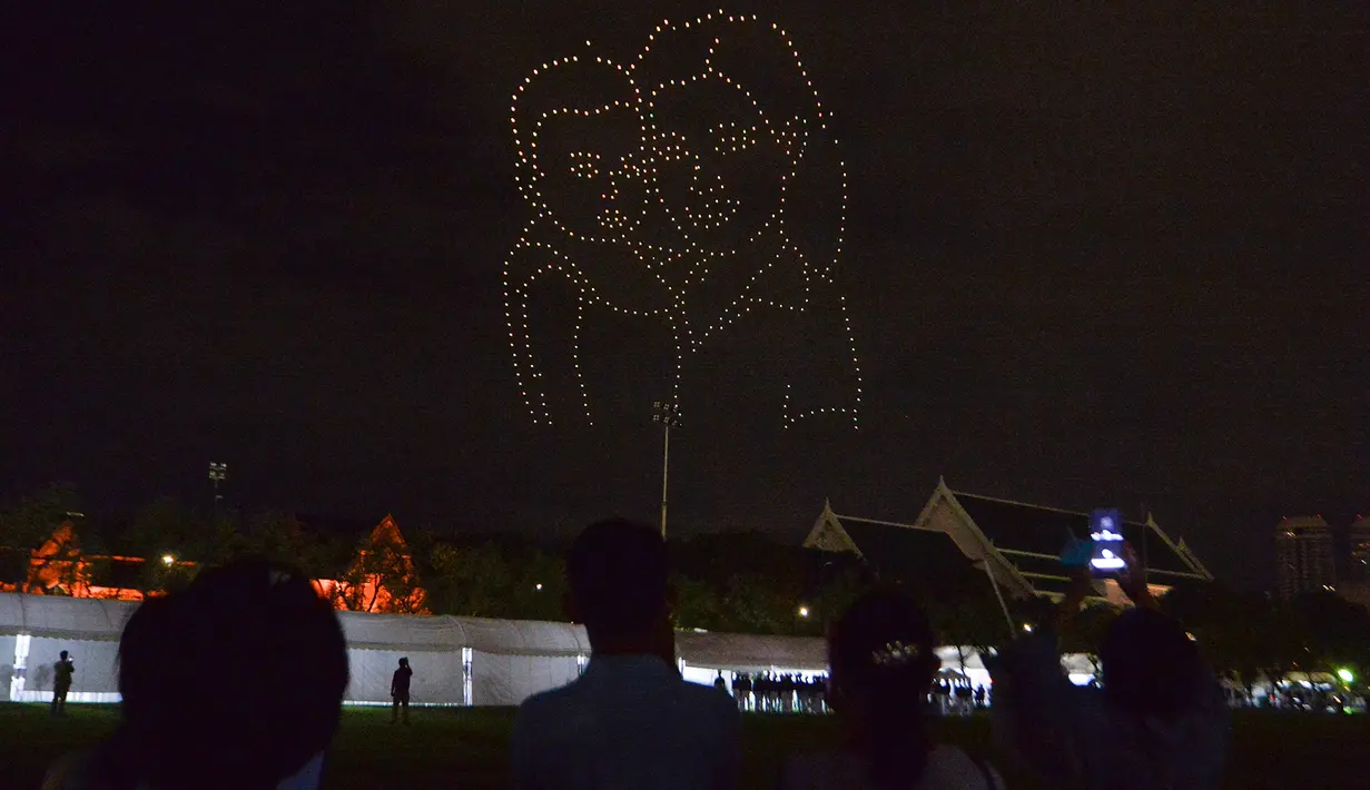 Orang-orang menyaksikan pertunjukan drone pada sebuah acara untuk merayakan ulang tahun ke-88 Ibu Suri Thailand, Ratu Sirikit, di dekat Grand Palace di Bangkok, Thailand, pada 12 Agustus 2020. (Xinhua/Rachen Sageamsak)