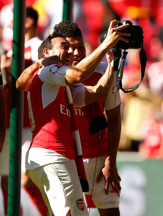 Gelandang Arsenal, Santi Carzola berselfie dengan Alex Oxlade Chamberlain saat merayakan kemenangan di Community Shield di Wembley Stadium, Minggu (2/8/2015). Arsenal menang atas Chelsea dengan skor 1-0. (Reuters/John Sibley)
