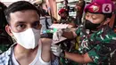 Anggota Marinir AL menyuntikan vaksin ketiga (booster) kepada warga di Pasar Palmerah, Jakarta, Selasa (19/4/2022). Vaksin ketiga (booster) terus ditingkatkan jelang libur lebaran. (Liputan6.com/Herman Zakharia)