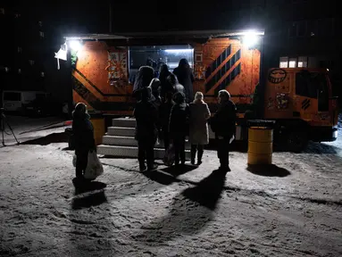 Warga mengantre di sebuah truk makanan milik the 3rd Separate Assault Brigade Angkatan Bersenjata Ukraina untuk mendapatkan makanan panas gratis bagi orang-orang di lingkungan perumahan yang rumahnya tanpa listrik setelah serangan udara Rusia berulang kali terhadap sektor energi negara itu di Kyiv, Selasa 27 Januari 2026. Gelombang serangan rudal dan pesawat nirawak (drone) besar-besaran Rusia yang menargetkan infrastruktur energi dan kawasan pemukiman di berbagai kota Ukraina, termasuk Kyiv dan Kharkiv, berimbas pada krisis energi. (AP Photo/Danylo Antoniuk)