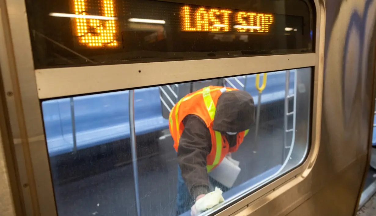 Pekerja otoritas transportasi kota New York membersihkan gerbong kereta bawah tanah di stasiun Coney Island di Brooklyn, Rabu (6/5/2020). Untuk pertama kalinya, sistem kereta bawah tanah New York dimatikan sementara agar dapat dibersihkan untuk menghentikan penyebaran virus corona (COREY SIPKIN/AFP)