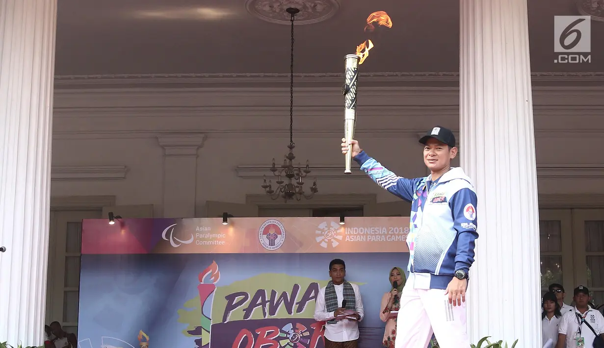 Ketua Umum INAPGOC Raja Sapta Oktohari mengacungkan api obor Asian Para Games saat pawai obor Asian Para Games 2018  di Balai Kota DKI Jakarta, Minggu (30/9). Api obor ini akan diarak di 17 titik lokasi di Ibu Kota. (Liputan6.com/Herman Zakahria)