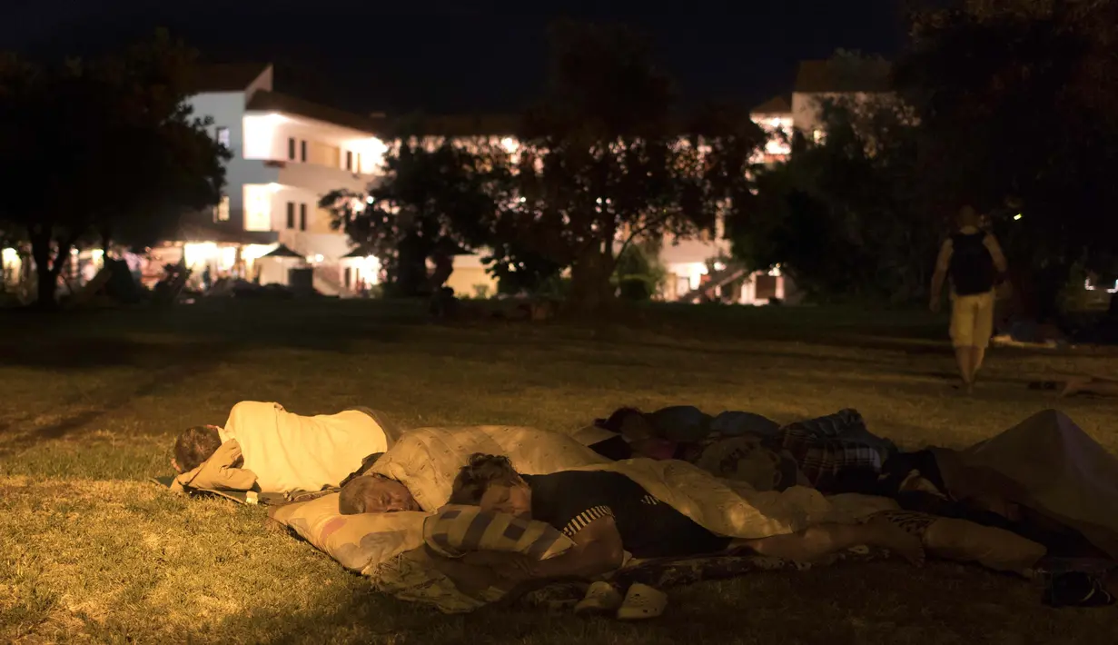 Warga tidur di taman bermain setelah gempa bumi 6,5 SR melanda Pulau Kos, Yunani, Sabtu (22/7). Gempa yang melukai 500 orang dan menewaskan dua orang membuat warga memilih tidur di luar rumah karena takut gempa susulan. (AP Photo/Petros Giannakouris)