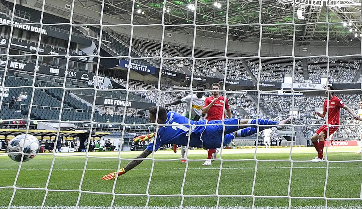 Pemain Borussia Moenchengladbach, Marcus Thuram, mencetak gol ke gawang Union Berlin pada laga Bundesliga di Stadion Borussia-Park, Minggu (31/5/2020). Moenchengladbach menang 4-1 atas Union Berlin. (AP/Martin Meissner)