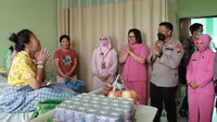 Kepala Polres Meranti AKBp Andi Yul menjenguk guru yang baru saja melahirkan saat peringatan Hari Guru Nasional. (Liputan6.com/M Syukur)