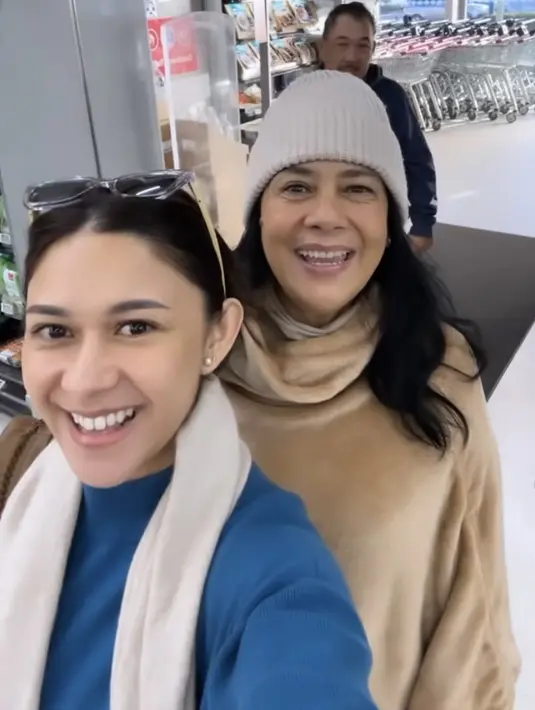 Nana tampil dengan jaket halter neck biru, dipadukan syal putihnya. Sedangkan Lydia mengenakan jaket turtleneck coklat lengkap dengan bennie. (@nanamirdad_)