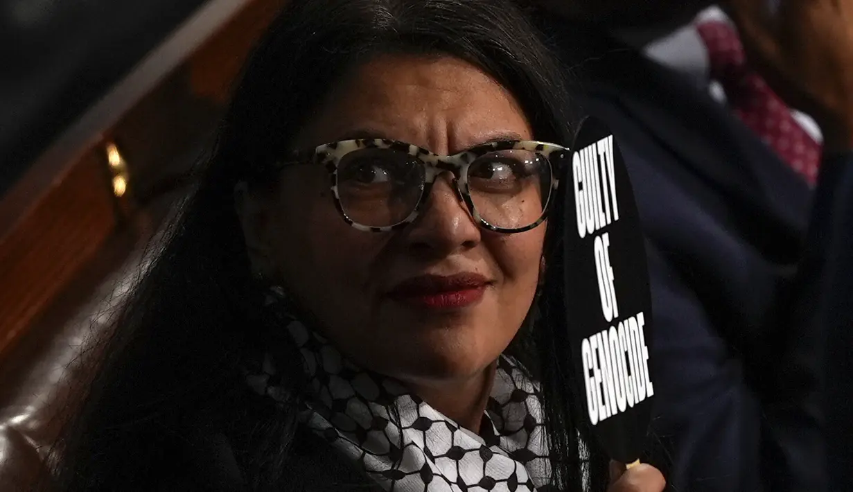 Rashida Tlaib  mengangkat sebuah papan bertuliskan “penjahat perang” dan “Bersalah atas genosida” di sisi lainny ketika Netanyahu berbicara. (AP Photo/Julia Nikhinson)