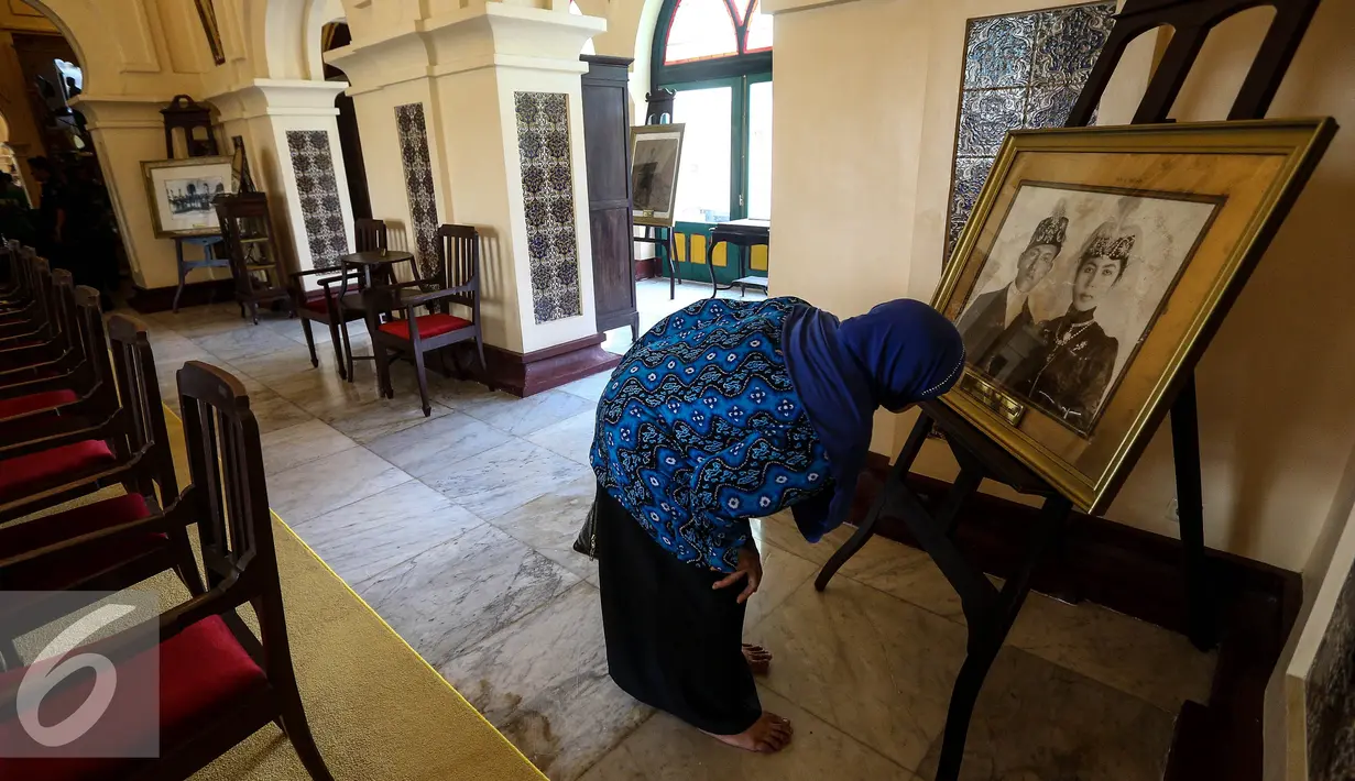 Pengunjung melihat keterangan foto yang dipajang di Istana Siak Sri Indrapura, Riau, Kamis (21/7). Istana Siak menyimpan banyak peninggalan sejarah Kerajaan Siak yang menarik perhatian pengunjung. (Liputan6.com/Faizal Fanani)
