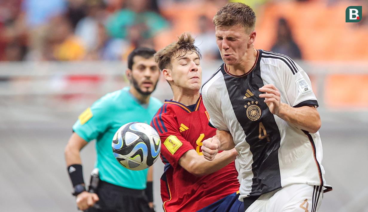 Ekspresi pemain Timnas Spanyol U-17, Pau Prim (tengah), saat berebut bola dengan pemain Jerman U-17, Finn Jeltsch, dalam pertandingan perempat final Piala Dunia U-17 2023 yang berlangsung di Jakarta International Stadium (JIS), Jumat (24/11/2023). (Bola.com/Bagaskara Lazuardi)