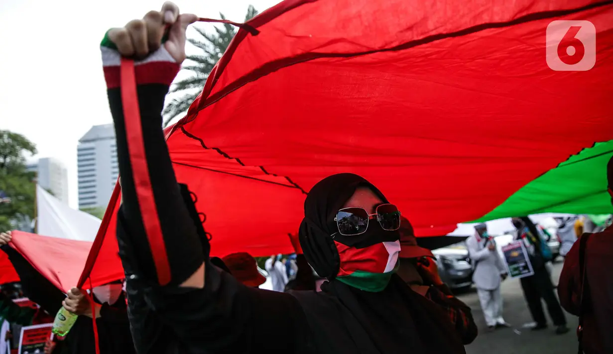 Pengunjuk rasa membentangkan bendera Palestina di depan Kedubes Amerika Serikat, Jumat (21/5/2021). Aksi yang diikuti berbagai elemen masyarakat dan ormas itu mengutuk serangan Israel dan mengajak masyarakat Indonesia untuk mendukung dan membantu Palestina. (Liputan6.com/Faizal Fanani)
