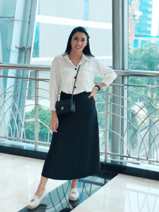 Tyas Mirasih cukup sering menggunakan pakaian berwarna putih dengan rambut tergerai. Tak jarang pula ia memadukannya menggunakan rok berwarna gelap. Terkesan simple dan santai, gaya Tyas Mirasih tetap terlihat nyaman. (Liputan6.com/IG/@tyasmirasih)