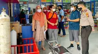 Polisi dan Satgas Covid-19 di Riau memantau persediaan oksigen dan obat penurun gejala Covid-19 di salah satu apotek. (Liputan6.com/M Syukur)