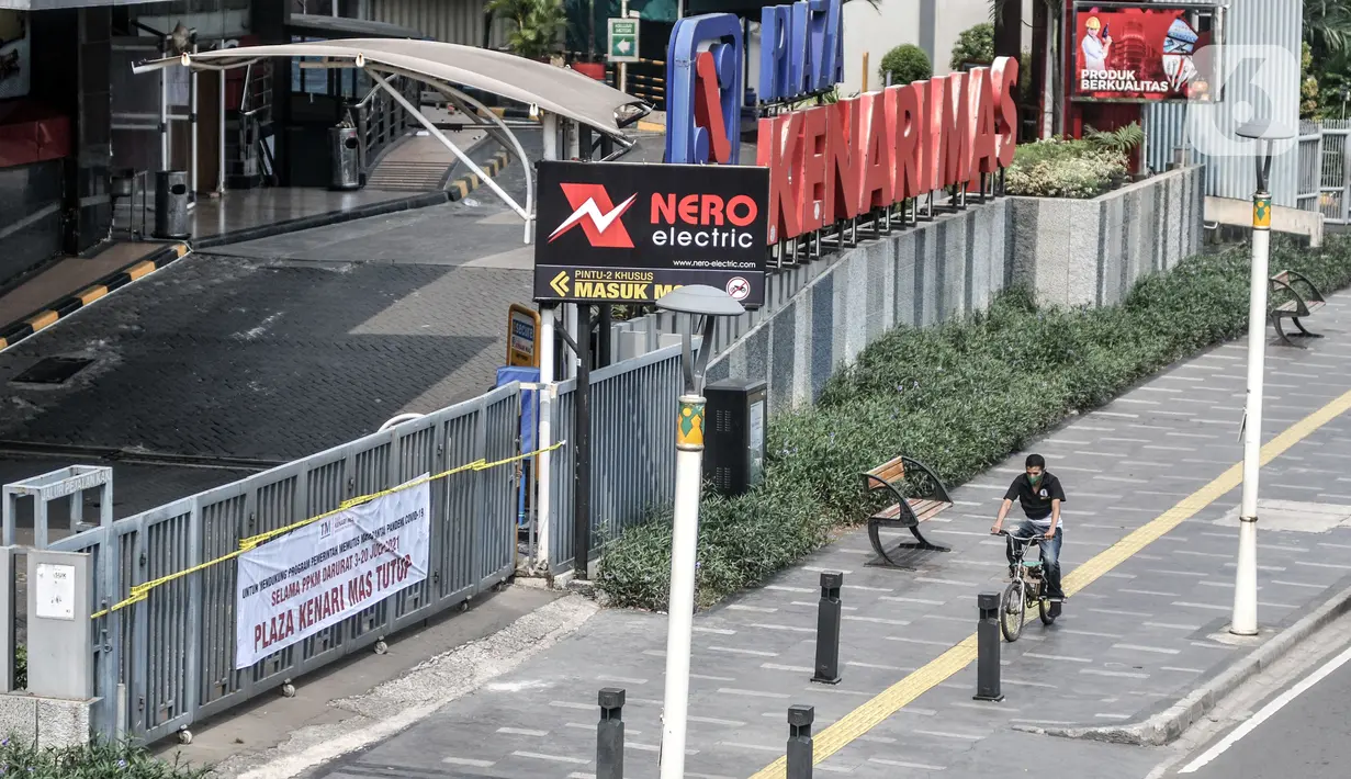 Pesepeda melintas di depan Plaza Kenari Mas yang tutup, Jakarta, Rabu (7/7/2021). Satgas COVID-19 DKI Jakarta menutup Plaza Kenari Mas setelah melanggar aturan dengan tetap beroperasi pada masa PPKM Darurat sehingga memicu kerumunan. (merdeka.com/Iqbal S. Nugroho)