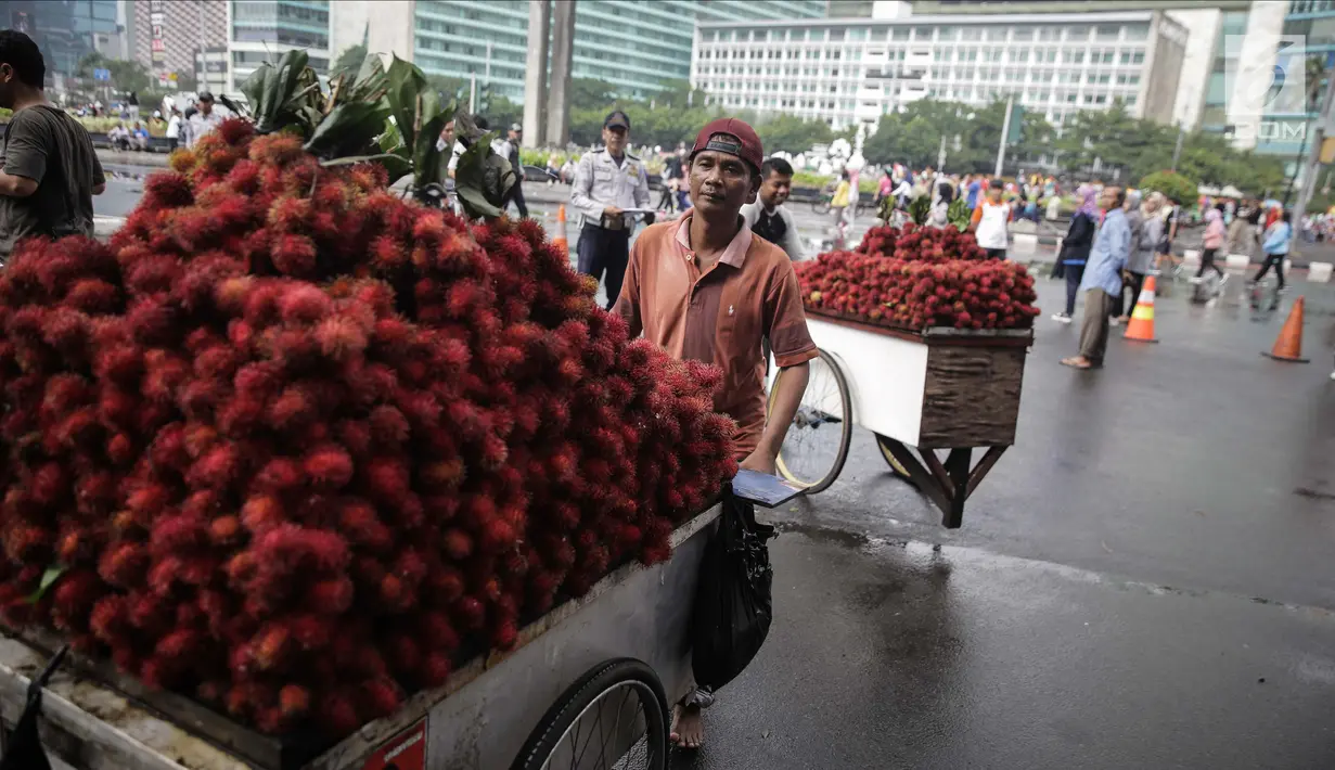 Pedagang buah rambutan meninggalkan lokasi CFD di kawasan Bunderan HI usai ditindak oleh Petugas Dinas Perhubungan, Jakarta, Minggu (4/2). Penindakan ini dilakukan agar kawasan CFD tertib dan rapih dari pedagang. (Liputan6.com/Faizal Fanani)