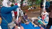 Orang-orang yang terluka saat gempa mendapatkan perawatan medis di tempat parkir rumah sakit di Cianjur, Jawa Barat, Indonesia, Senin (21/11/2022). Kepala Badan Nasional Penanggulangan Bencana (BNPB) Suharyanto menyebut korban meninggal sudah mencapi 20 orang dan luka-luka sebanyak 17 orang. (AP Photo/Firman Taqur)