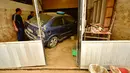 Warga memeriksa mobil yang rusak setelah banjir bandang menerjang Tafalla, Spanyol, Selasa (9/7/2019). Badan Meteorologi Spanyol, AEMET, menerbitkan peringatan waspada banjir dan longsor di sejumlah wilayah. (AP Photo/Alvaro Barrientos)