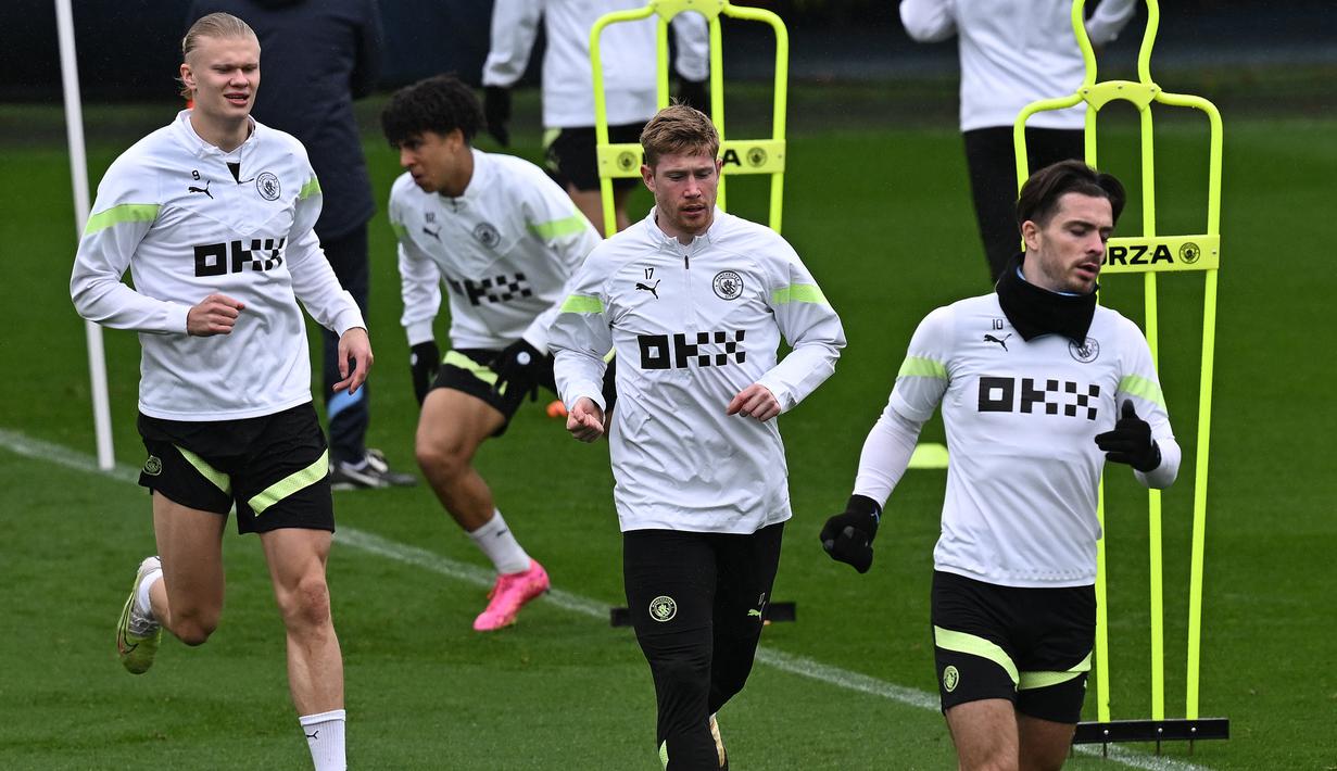 Penyerang Manchester City, Erling Haaland (kiri), gelandang Kevin De Bruyne (tengah) dan Jack Grealish melakukan pemanasan selama sesi latihan tim di tempat latihan Manchester City di Manchester, barat laut Inggris pada 8 Mei 2023. (AFP/Paul Ellis)