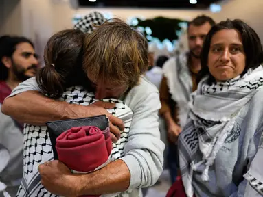 Para aktivis kemanusiaan Global Sumud Flotilla (GSF) saling berpelukan saat tiba di Bandara Istanbul, Turki, Kamis 21 Mei 2026. (AP Photo/Emrah Gurel)
