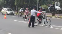 Petugas mengarahakan pesepeda non road bike saat memasuki JLNT Kampung Melayu-Tanah Abang, Jakarta, Minggu (30/5/2021). Uji coba kedua ini bertujuan kembali mendapatkan masukan dari penggiat sepeda secara lengkap baik dari sisi operasional maupun teknis kedepannya. (Liputan6.com/Herman Zakharia)