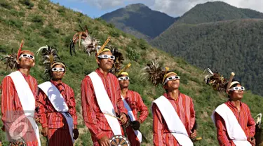 Seniman memakai kacamata melihat gerhana matahari di Bukit Matantimali, Sigi, Sulawesi Tengah, Rabu (9/3). Tarian tersebut dilakukan dalam rangka menyambut gerhana matahari total serta menolak bala. (Liputan6.com/Immanuel Antonius)